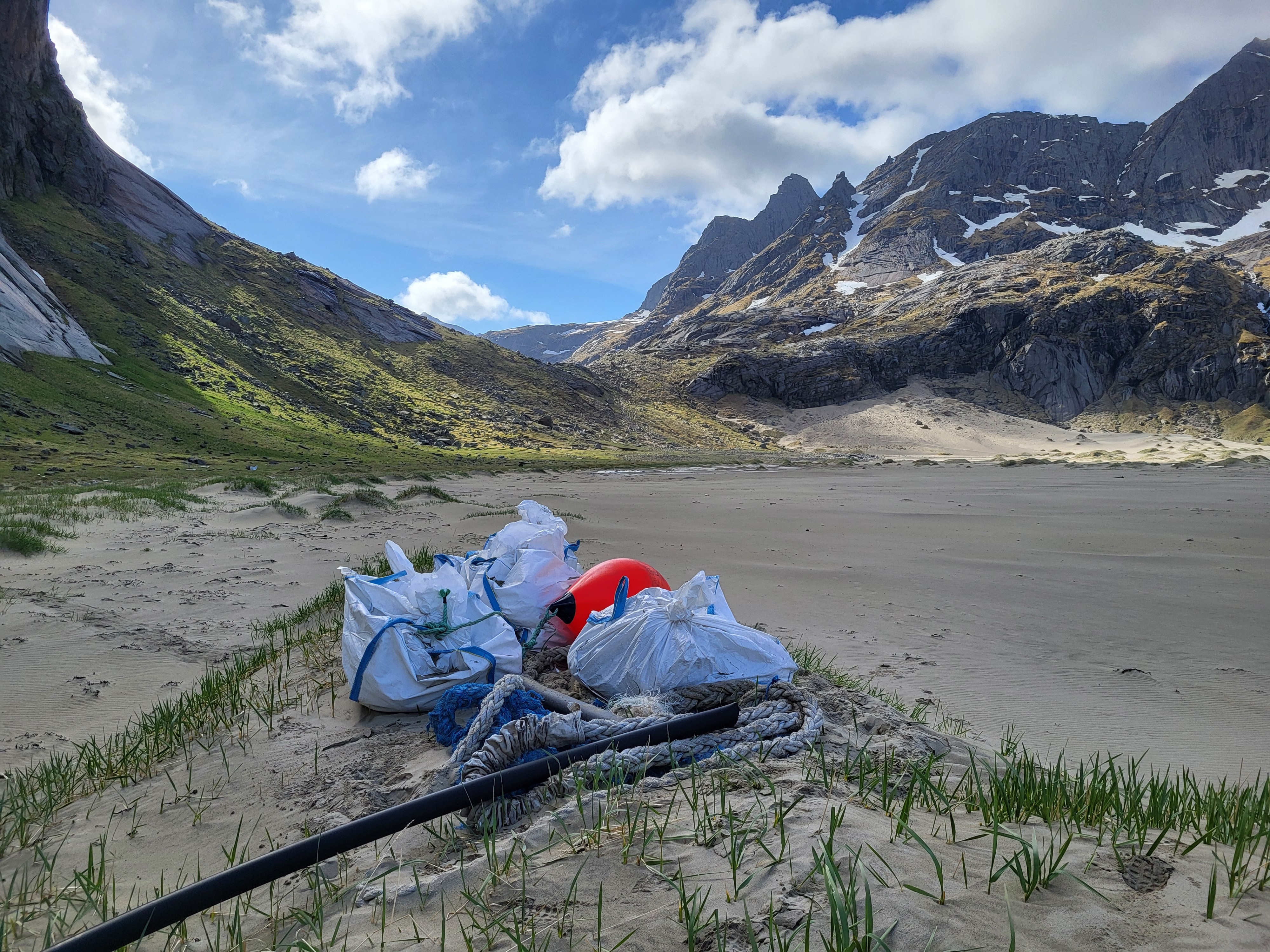 Flere store sekker med marint avfall som er samlet inn på sandstranden Bunessanden i Lofotodden nasjonalpark