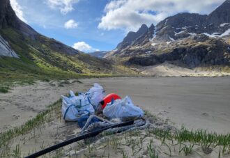 Flere store sekker med marint avfall som er samlet inn på sandstranden Bunessanden i Lofotodden nasjonalpark